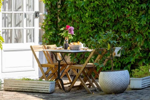 Terrasse privative verdoyante avec table et fleurs, appartement mmeubléespace détente maison d’hôtes à Evry, Essonne, France, charme, confort, ambiance paisible