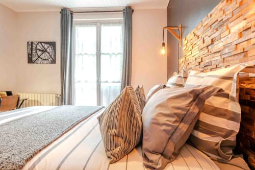 Chambre lumineuse avec tête bois, coussins élégants, ambiance chaleureuse maison d’hôtes à Evry, Essonne, France, confort, charme, détente