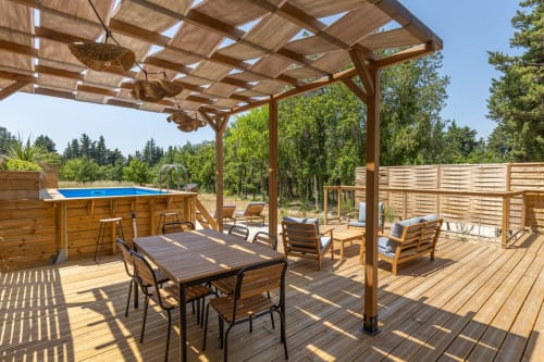 Terrasse ombragée avec salon de jardin et pergola, parfaite pour les apéritifs en fin de journée.