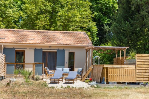 Jardin arboré avec piscine privée, transats au pied du massif des Alpilles.