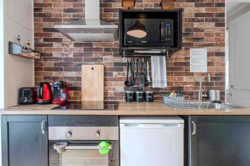 Cuisine équipée moderne avec électroménager, crédence brique, maison d’hôtes à Evry, Essonne, France, pratique, conviviale, confort, charme