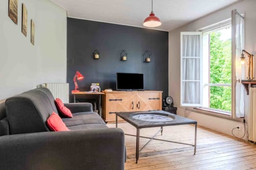 Salon cosy avec canapé et lumière naturelle, espace chaleureux maison d’hôtes à Evry, Essonne, France, confort, détente, charme, convivialité