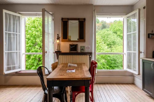 Salle à manger lumineuse avec grandes fenêtres verdoyantes, ambiance conviviale maison d’hôtes à Evry, Essonne, France, charme, détente, accueil chaleureux