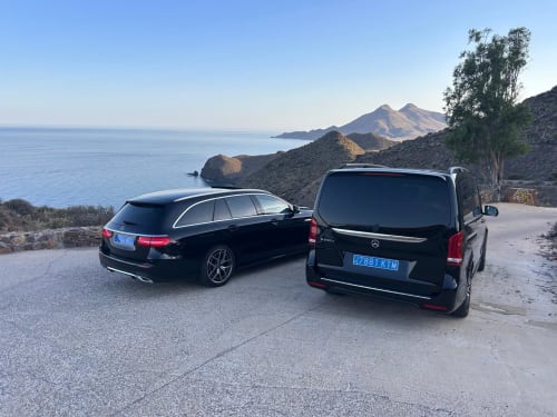 Dos vehículos Mercedes negros estacionados en un mirador costero pintoresco cerca de Carboneras con montañas volcánicas y el mar Mediterráneo