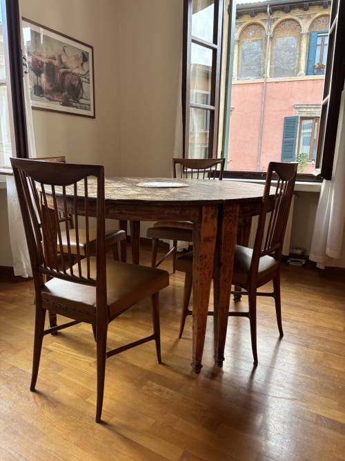 Elegante sala da pranzo a Dimore Verona con tavolo rotondo in legno, sedie e vista panoramica di Verona dalle ampie finestre
