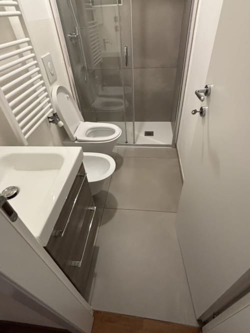 Bagno moderno dell'appartamento Dimore Verona a Verona con lavandino, toilette e doccia in vetro