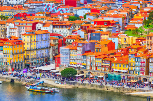 Colorful hilltop buildings with orange roofs overlooking Porto's Douro River waterfront
