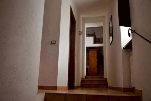 Moderno corridoio della Residenza San Jacopo B&B a Spello con porte in legno e pavimenti in cotto