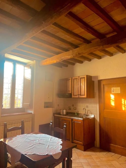 Accogliente angolo cottura rustico con travi in legno a vista, tavolo da pranzo e vista sulla città, Residenza San Jacopo, Spello