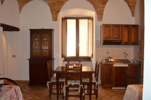 Cucina e sala da pranzo rustica a Residenza San Jacopo, Spello, con mobili in legno e soffitti a volta
