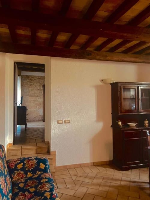 Ampio living in Residenza San Jacopo con travi in legno a vista, pavimenti in cotto, mobili in legno scuro