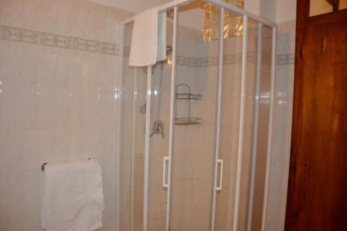 Moderna cabina doccia in vetro con scaffalature metalliche nel bagno dell'appartamento Residenza San Jacopo, Spello