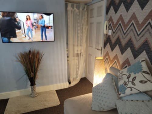 Modern studio apartment at Jane's B&B with flat screen TV, chevron wallpaper, sitting area and contemporary furnishings in