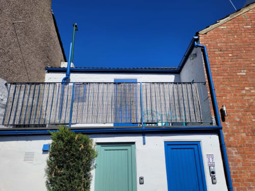 Jane's B&B Room 27 exterior in Guisborough with blue railings, mint green door, and brick building facade