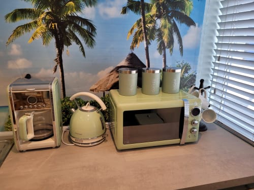 Retro kitchen appliances display with cream-colored coffee maker, kettle, microwave, and storage containers at Jane's B&B,
