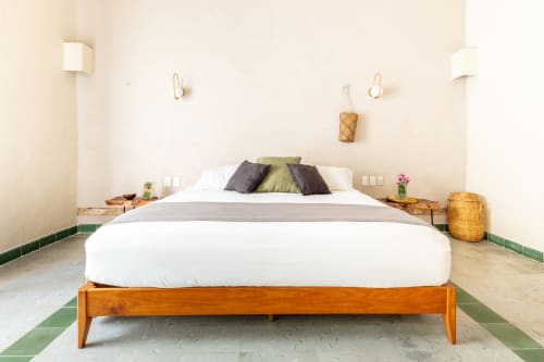 Dormitorio luminoso y minimalista en Casa Tuch B&B, Mérida, con cama de madera, sábanas blancas y detalles de azulejos verdes
