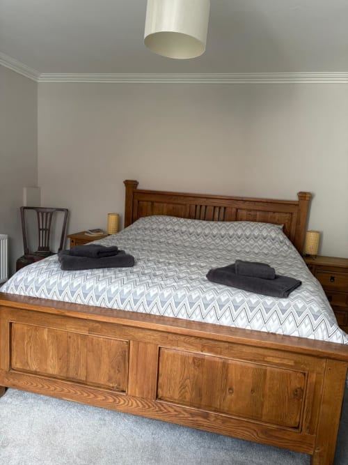 Spacious Super King bedroom at Eglinton Road Bray with wooden bed, geometric patterned duvet, and bedside lamps
