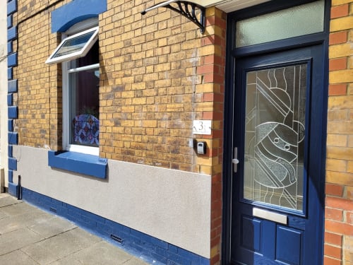 Blue and cream exterior of No 3 Lingdale house in Guisborough with blue door, window, and brick facade