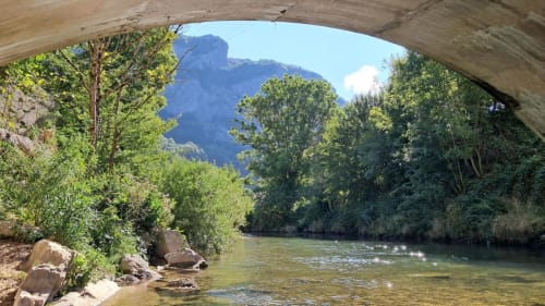 Vue sur la rivière sous un pont de pierre avec montagnes et forêt à la Maison de Sophie, Rencurel France