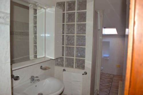Bagno moderno con doccia in vetro, lavabo rotondo e pareti piastrellate nell'appartamento a Spello