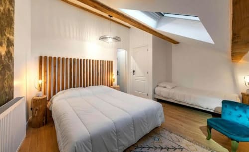 Chambre lumineuse sous les combles à la Maison de Sophie B&B à Rencurel, avec poutres en bois, puits de lumière et sièges bleus