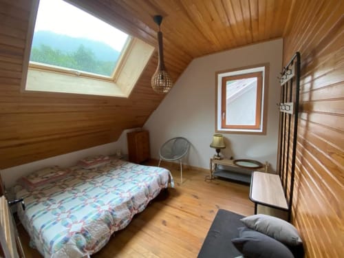 Cozy wooden villa bedroom with mountain views, skylights, bed, and modern amenities at Locavilla