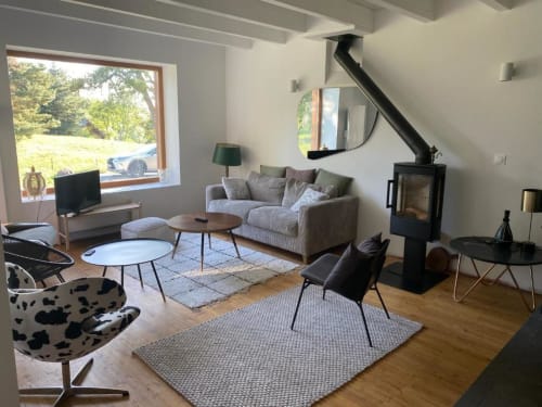 Modern villa living room with sofa, fireplace, mountain views, and contemporary furnishings in Colombes