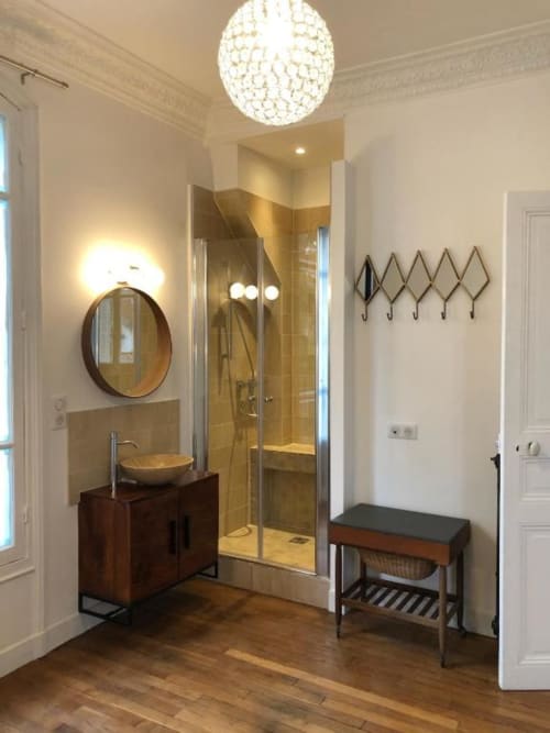 Modern bathroom in Villa Saint-Hilaire at Locavilla with round mirror, vessel sink, glass shower enclosure, and wooden