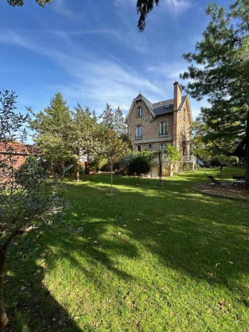 Charming stone villa with expansive garden at Locavilla in Colombes, featuring manicured lawns and mature trees