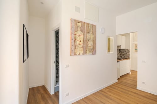 Appartamento Modern Art Gallery a Roma con pavimenti in legno, pareti bianche, opere d'arte astratta e cucina a vista