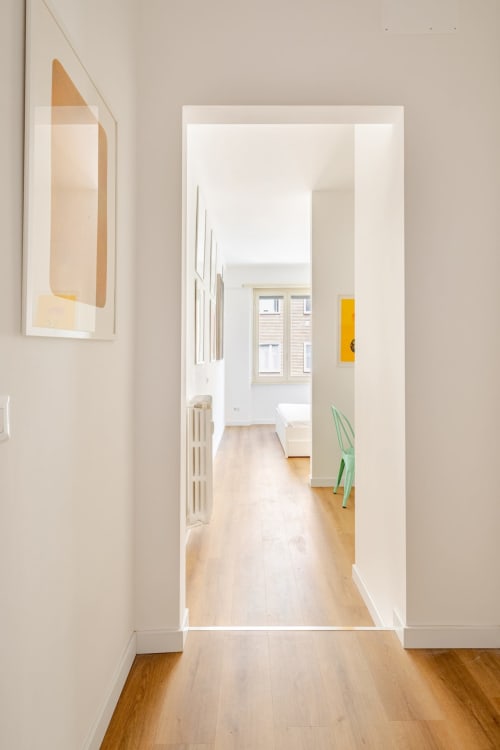 Luminoso corridoio con pavimenti in legno che conduce attraverso un'ampia porta nella casa d'arte a Roma