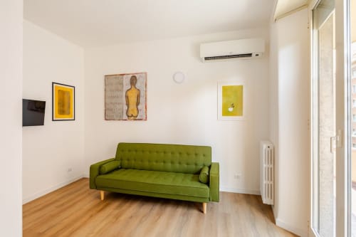 Appartamento Modern Art Gallery a Roma con divano verde, pavimento in legno, opera gialla e aria condizionata