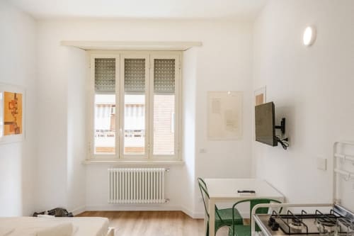 Luminoso appartamento minimalista a Roma con finestre a triplo vetro, riscaldamento, TV, sedia verde e angolo cottura