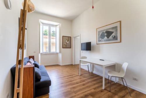 Appartamento Modern Art House in Piazza del Popolo a Roma con zona living, scrivania, TV e comodo divano nero.