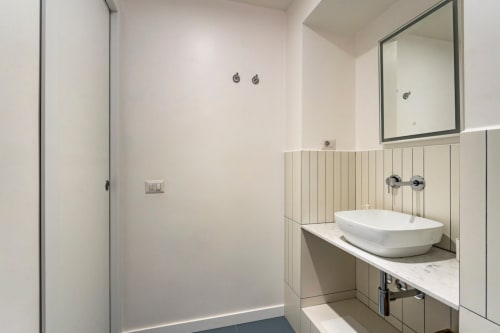 Bagno moderno nell'appartamento Art House Roma con lavabo a coppa, specchio da vanità, rubinetto a parete e rivestimento in shiplap verticale