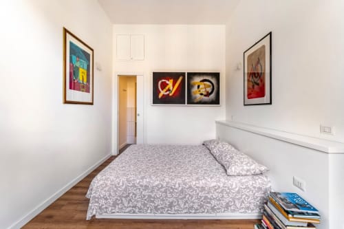 Camera da letto moderna presso Art House Rome con letto, pavimento in legno, quadri incorniciati e porta verso il corridoio