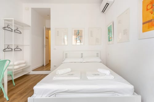 Camera da letto moderna e luminosa ad Art House apartment a Roma, con letto, armadio, arte murale colorata e pavimenti in legno