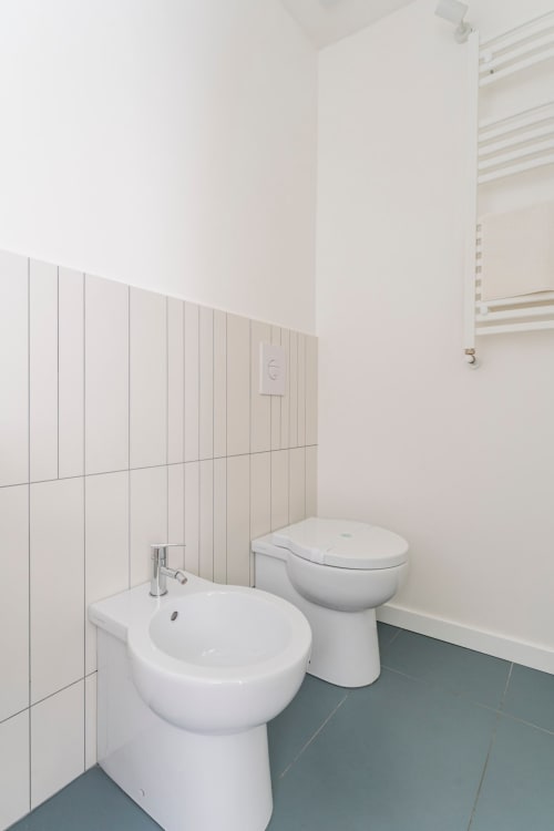 Bagno moderno in bianco presso l'appartamento Art House Villa Borghese a Roma, con bidet, WC e lavabo su colonna