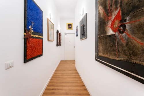 Corridoio della galleria d'arte contemporanea di Art House Rome con dipinti colorati e pavimenti in legno