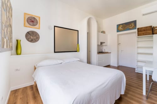 Camera moderna e luminosa all'Art House Roma con letto matrimoniale, opere d'arte, angolo cottura e pavimenti in legno a Villa Borghese