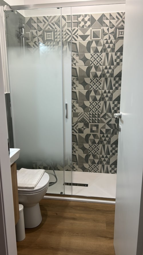 Bagno moderno in appartamento Villa Torlonia Art House a Roma, con parete decorativa in piastrelle geometriche e doccia in vetro
