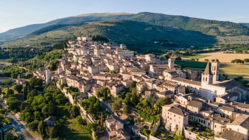 Vista aerea del borgo medievale di Spello con edifici in pietra e la Residenza San Jacopo B&B tra i coppi