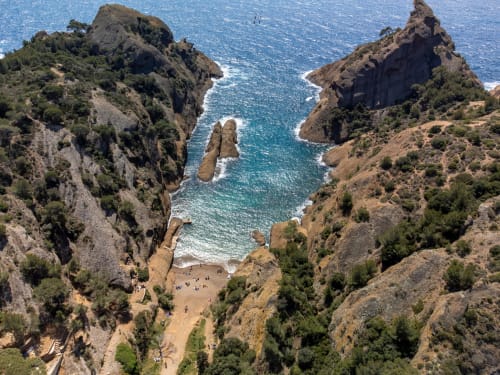 Falaises côtières dramatiques avec une crique isolée et des eaux turquoise méditerranéennes