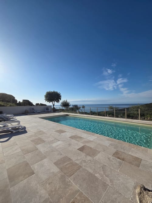 Piscine de luxe aux eaux turquoise avec vue sur la mer Méditerranée à la Résidence Lésia à Corbara