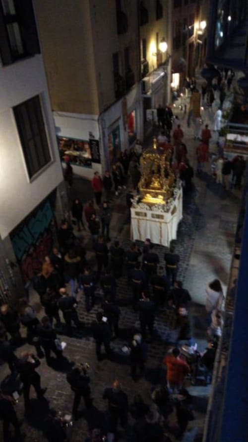 Vista nocturna de la calle de Granada con santuario dorado iluminado, multitudes reunidas en angosto callejón europeo cerca del hotel CTH Granada
