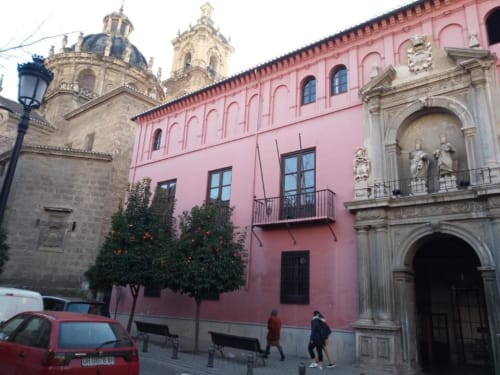 Edificio colonial rosa con torres de catedral, Granada España - vista emblemática del apartamento CTH Granada