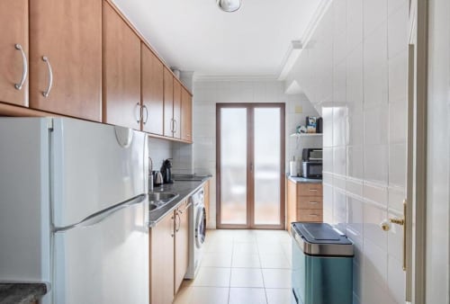 Cocina moderna en apartamento CTH Granada, Armilla con muebles de madera, electrodomésticos de acero inoxidable y piso de cerámica
