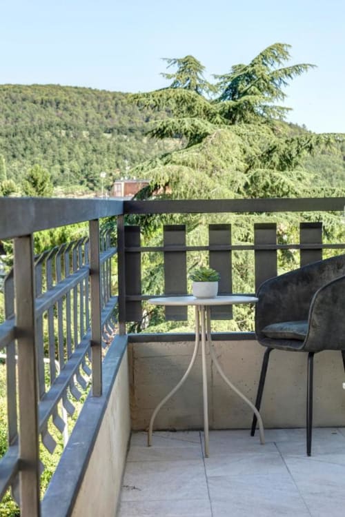 Balcony terrace at Palazzo Belvedere hotel with forested hillside views, Chianciano Terme