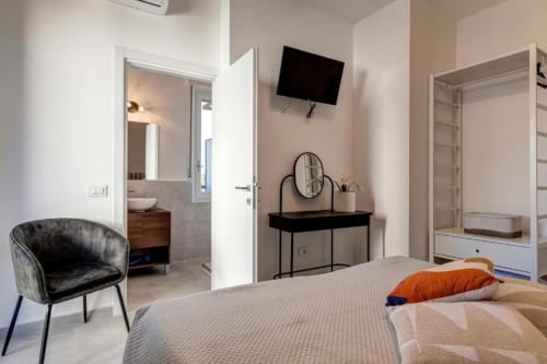 Modern double bedroom at Palazzo Belvedere hotel in Chianciano Terme with bed, desk, chair, and en-suite bathroom