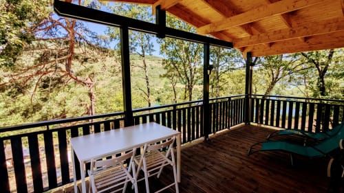 Terrazza di lodge schermate con tavolo da pranzo affacciato su montagne boscose e fiume a Serrières-sur-Ain